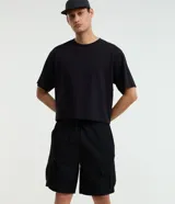 Bermuda cargo baggy negra, confeccionada en poliéster con cintura elástica, cordón ajustable y bolsillos laterales con cierre de cremallera.