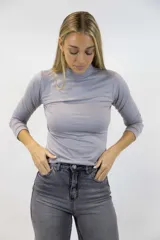 Polera color beige de manga larga y cuello alto, confeccionada en tejido ajustado al cuerpo.