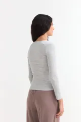 Remera de manga larga con cuello redondo a la base, confeccionada en tejido acanalado de ajuste entallado.