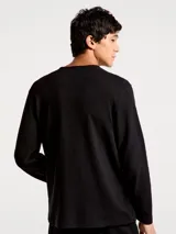 Camiseta térmica de manga larga con cuello redondo y cierre frontal de tres botones, confeccionada en tejido de punto con textura acanalada.