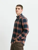 Camisa de franela de manga larga con estampado de cuadros escoceses, cuello button-down y cierre frontal con botones.