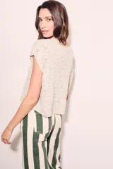 Chaleco de punto color crema con detalles en rosa y celeste, de corte holgado y mangas cortas.