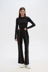 Pantalón negro de viscosa, corte ajustado y cintura alta, con línea vertical blanca a lo largo de la pierna.