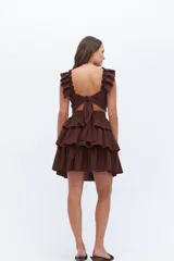 Falda corta marrón oscuro con cintura alta y tres volados superpuestos con efecto arrugado.