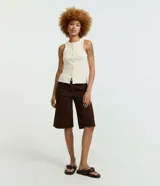 Musculosa de rib color off-white, con cuello redondo, sin mangas y abotonado frontal.