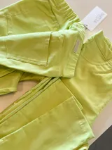 Pantalón de gabardina color lima, con cintura elástica, bolsillos traseros tipo parche y detalles de costuras pespunteadas.