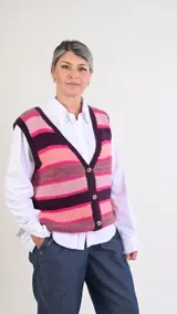 Chaleco de punto tejido a mano con lana 100% merino, con diseño de rayas horizontales en tonos rosados, bordo y marrón. Cuenta con escote en V y cierre frontal con tres botones.