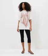 Remera de corte regular y manga corta, confeccionada en algodón. Presenta cuello redondo y una estampa frontal que simula un vestido de breteles finos con detalles de encaje.