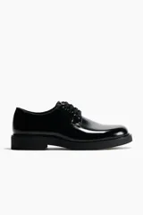 Zapatos Blucher negros de tejido revestido con acabado brillante, cordones abiertos, forro de lona de algodón y suela de goma con textura.