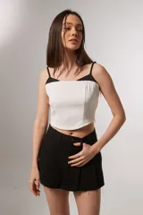 Top blanco con escote recto, breteles finos negros y corte cropped.