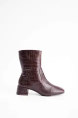 Bota de caña media con textura de reptil, confeccionada en cuero vacuno color marrón, con taco cuadrado bajo.