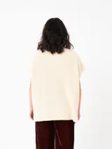 Chaleco tipo poncho de tejido de punto color tostado, con cuello polera y diseño holgado con laterales abiertos.