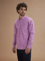 Camisa de manga larga color lila con cuello abotonado y bolsillo en el pecho.