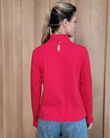 Polera de manga larga color blanco, confeccionada en algodón, con cuello alto tipo tortuga y detalles de volados en el cuello y en los puños.