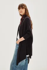 Cardigan largo tipo poncho o chalina, color negro liso, de tejido suave y caída fluida.