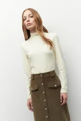 Polera de cuello alto y manga larga, confeccionada en tejido suave y elástico, con un ajuste al cuerpo.