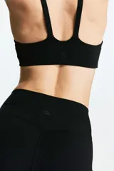 Top deportivo negro de soporte medio, con breteles dobles y espalda deportiva.