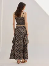 Falda midi de tiro alto y silueta evasé, confeccionada en algodón con diseño estampado geométrico en tonos verdes, naranjas y celestes. Cuenta con caída fluida, ruedo ligeramente acampanado y dos bolsillos cuadrados laterales.