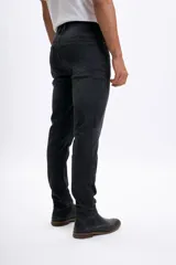 Pantalón de jean slim fit color gris oscuro, con desgaste en la parte superior de los muslos y ruedo con dobladillo.