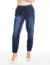Pantalón tipo jogger de denim azul con efecto lavado. Presenta cintura elástica con cordón ajustable, bolsillos laterales y traseros, y puños elásticos en los tobillos.