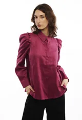 Camisa blanca de lino con cuello clásico, mangas largas con volumen y frunces en los hombros.