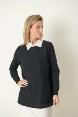 Buzo verde oliva de punto fino con detalle de líneas diagonales en el mismo material y cuello camisero blanco.