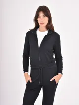 Monoprenda de estilo deportivo color negro, con cierre frontal parcial, mangas largas y cintura elástica con cordón ajustable. Presenta un diseño de pantalón tipo jogger con puños en los tobillos.