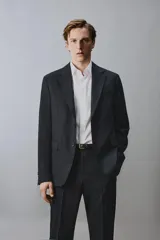Blazer de corte regular confeccionada en lana de origen italiano, con diseño a cuadros sutiles. Presenta cuello con solapas de muesca, cierre frontal de un botón, bolsillos laterales con solapa y bolsillo en el pecho. Cuenta con aberturas en la espalda y forro interior.