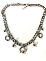 Gargantilla plateada de cadena gruesa con dijes colgantes de aros y esferas.