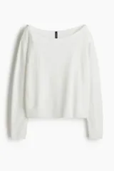 Buzo de punto fino color blanco, con escote amplio tipo barco que deja los hombros descubiertos y remates acanalados en puños y bajo.