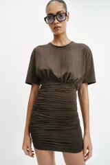 Vestido corto de manga corta y cuello redondo, confeccionado con mezcla de algodón. Presenta un diseño ajustado con drapeado lateral en la falda.
