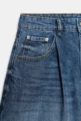 Shorts denim de tiro alto y corte relaxed, confeccionados en tejido vaquero celeste claro. Presentan trabillas en la cintura, diseño de cinco bolsillos, pliegues frontales y cierre con cremallera y botón metálico.