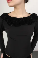 Top negro de mangas largas con escote bote y trenza de terciopelo en el cuello.