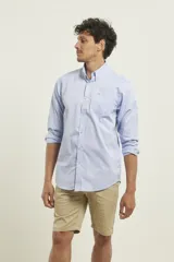 Camisa celeste de algodón con cuello abotonado, manga larga con puños abotonados y bolsillo en el pecho. Corte clásico.
