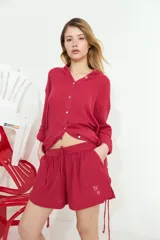 Short rojo de algodón con bolsillos delanteros, cintura elástica con cordón ajustable y detalle bordado.