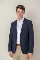 Saco azul marino de corte slim fit confeccionado en tencel, con solapa de muesca, cierre de dos botones, bolsillo de parche en el pecho y bolsillos laterales con solapa.