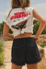 Shorts de jean de tiro alto con diseño curvo, cinco bolsillos y trabillas para cinturón. Presenta roturas desgastadas y bajo con acabado deshilachado. Cierre frontal con cremallera y botón metálico.
