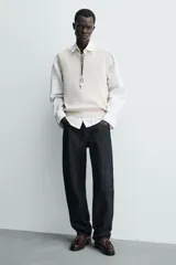 Mocasín de vestir color marrón oscuro, con parte superior lisa, detalle de antifaz con borlas en el empeine y horma redonda. Suela de goma a tono.