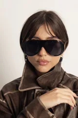 Lentes de sol estilo aviador con armazón de policarbonato en tono ámbar translúcido y cristales degradados en tonos marrones. Cuentan con protección UV400.