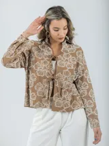 Camisa color crema con bordados florales, de corte recto y mangas largas.