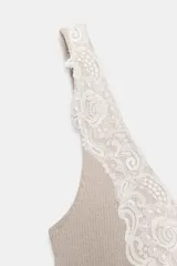 Top de punto canalé en color beige, con escote en pico adornado con una delicada aplicación de encaje blanco y tirantes anchos.