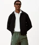 Campera masculina Blue Steel de corte boxy, color negro, con cuello inglés, cierre frontal de cremallera, manga larga, puños y ruedo elásticos, y detalles de recortes.