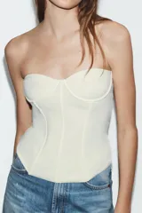 Corsé color bordó con aros y varillas, confeccionado en tejido elástico. Presenta escote corazón y diseño sin hombros.