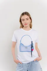 Remera blanca de algodón con estampado de un bolso azul con llavero.