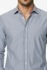 Camisa de algodón de manga larga con diseño de rayas verticales en tonos gris y blanco, cuello camisero clásico y cierre frontal con botones.