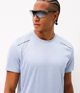 Remera deportiva de manga corta y cuello redondo, color celeste, con tecnología dry y detalles reflectantes en los hombros.