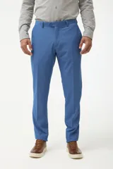 Ambo de vestir color azul, compuesto por saco con solapa en punta y pantalón a juego. El saco cuenta con cierre frontal de dos botones y bolsillos laterales con solapa.