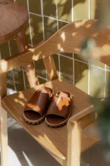 Sandalia tipo chinela de cuero marrón con textura granulada, plantilla de cuero y suela de madera con base de goma.