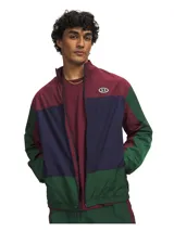 Campera deportiva Under Armour modelo Icon Woven Track FZ, con diseño colorblock en tonos bordó, azul marino y verde. Cuenta con cierre frontal completo, cuello alto y bolsillos laterales.