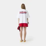 Remera oversized de algodón blanca, de manga corta y cuello redondo, con estampado gráfico multicolor en la espalda.